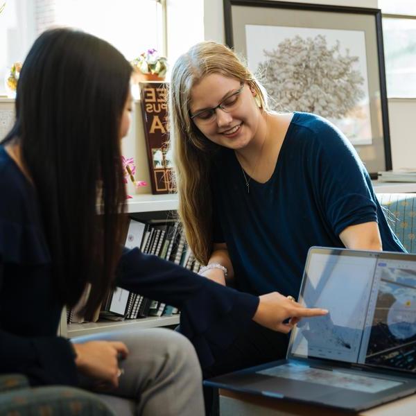 Two psychology major students reviewing images of brain scans on a laptop.